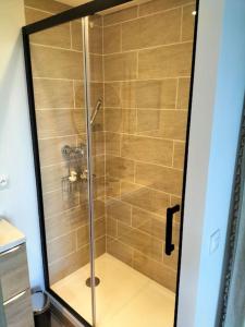 a shower with a glass door in a bathroom at ptit cocon in Le Fournet +12 photos