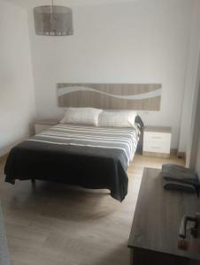 ein Schlafzimmer mit einem Bett und einem Tisch in der Unterkunft Alquiler Vivienda Completa Don Enrique in Cartagena + 10 Fotos