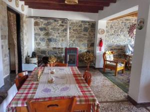 a dining room with a table and a stone wall at Lydia in Samos
