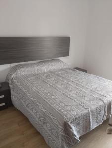 ein Schlafzimmer mit einem Bett mit einer weißen Bettdecke in der Unterkunft Alquiler Vivienda Completa Don Enrique in Cartagena