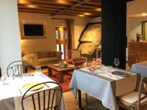 a dining room with two tables and a living room at Hotel Gredos María Justina in Navacepeda de Tormes