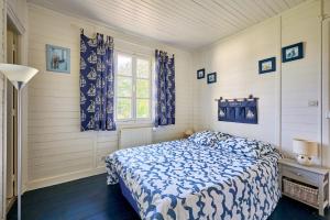 a bedroom with a bed and a window at La Chaumière bleue - Maison plage à 7min à pied in Manvieux