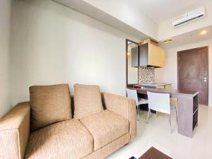 a living room with a couch and a table at Fancy 2BR at Skyland City Jatinangor Apartment By Travelio in Sumedang