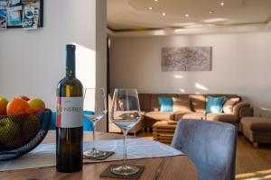 a bottle of wine sitting on a table with two wine glasses at Nerica Apartment in Zavalatica
