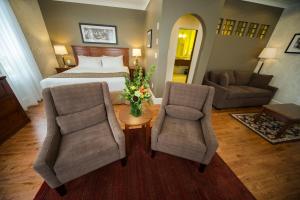 um quarto de hotel com uma cama e duas cadeiras em Hume Hotel & Spa em Nelson