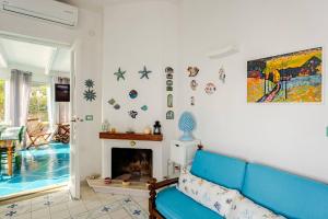 a living room with a blue couch and a fireplace at Casa FeFe Positano in Positano