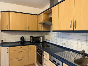 a kitchen with wooden cabinets and a black counter top at Ferienwohnung Seidl in Furth im Wald