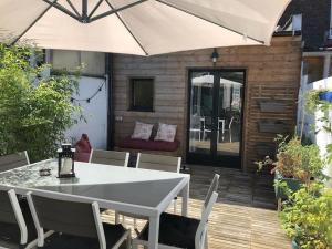 a table and chairs with an umbrella on a deck at Jolie maison de ville au calme in Marcq-en-Baroeul +5 photos