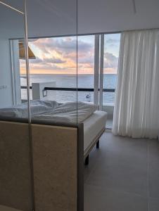 Un dormitorio con una cama y vista al mar. en Sonido del mar Gran Canaria - Montemarina - luxury panoramic view, en Mogán