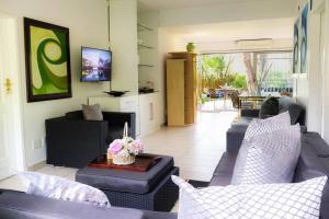 a living room with two couches and a table at Vaal River Garden Cottage in Theoville