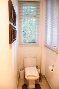 a bathroom with a white toilet and a window at Vaal River Garden Cottage in Theoville +17 photos