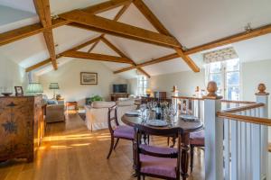 a dining room and living room with a table and chairs at Buckstone House Coach House in Coleford +17 photos