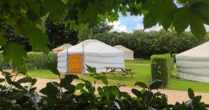 a yurt with a picnic table and a bench at Camping Kerlaudy La pause Atypi'k in Plouénan +51 photos
