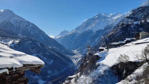 a view of a snowy mountain valley with snow covered mountains at Mattertal Lodge in Embd
