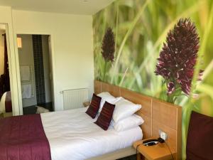 a bedroom with a bed with white sheets and pillows at Logis Hotel Restaurant Le Bellevue in Prats-de-Mollo-la-Preste