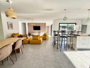 a kitchen and living room with a table and chairs at Jolie villa avec piscine classée 4 étoiles in Mios