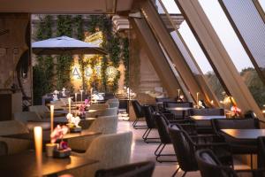 a dining room with tables and chairs and windows at The First Musica - Preferred Hotels & Resorts in Rome