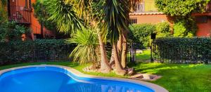 a swimming pool in a yard with palm trees at The Gem - Trastevere Cozy Retreat with pool in Rome