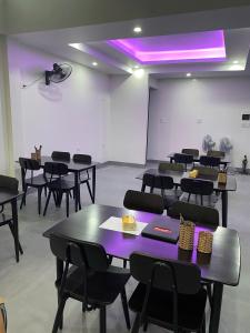 a room with tables and chairs in a room with purple lighting at Center Tam Coc Homestay in Ninh Binh