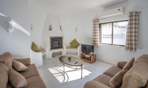 a living room with a couch and a tv at Carosim - Quiet location, close to beach, private in Poço Partido