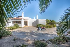 a motorcycle parked in front of a white house at Carosim - Quiet location, close to beach, private in Poço Partido
