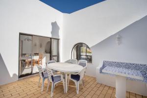 a dining room with a white table and chairs at Carosim - Quiet location, close to beach, private in Poço Partido
