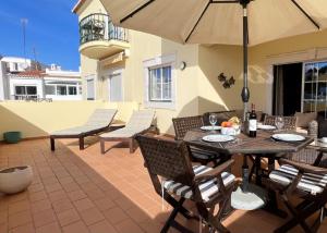 a patio with a table and chairs and an umbrella at Carvoeiro terrace - Stay in the heart of Carvoeiro in Carvoeiro