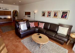 a living room with a leather couch and a table at Carvoeiro terrace - Stay in the heart of Carvoeiro in Carvoeiro