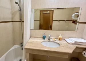 a bathroom with a sink and a mirror and a tub at Carvoeiro terrace - Stay in the heart of Carvoeiro in Carvoeiro +15 photos