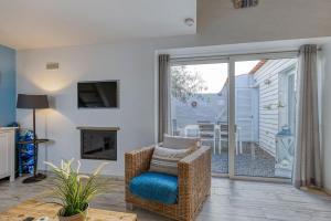 Quintal da Oliveira - Center apartment في برايا دو كارفويرو: غرفة معيشة مع كرسي وباب زجاجي منزلق