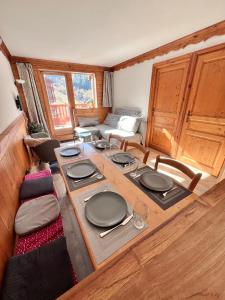 a table with plates on it in a living room at Appartement cosy 5-6p aux pieds des pistes 2 chambres 2 sdb in Oz +27 photos