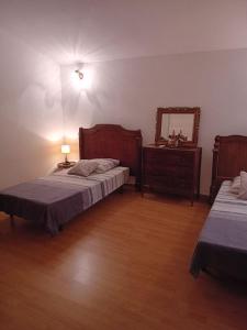 una camera con due letti, un comò e uno specchio di Cottage bergerie en pierres avec jacuzzi en corse 6 personnes, 3 chambres a Coti-Chiavari