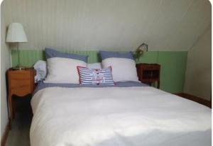 ein Schlafzimmer mit einem großen weißen Bett und Kissen in der Unterkunft Nid de Corsaire, Vue Mer & Accès plage in Saint-Malo