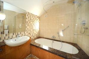 a bathroom with a tub and a sink and a shower at The Star Inn 1744 in Thrussington +37 photos