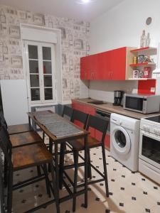 a kitchen with a table and chairs and a washing machine at Sweet home in Cholet
