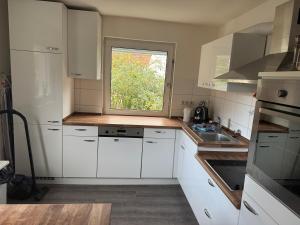 a small kitchen with white cabinets and a window at FeWo Tanja in Lindau