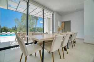 a dining room with a wooden table and chairs at Luxury Oasis Villa in Peyia