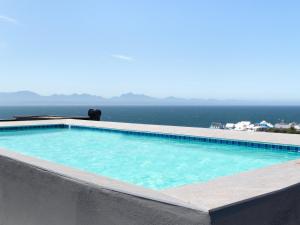 a swimming pool with the ocean in the background at 201 & 210 Mossel Cove in Mossel Bay