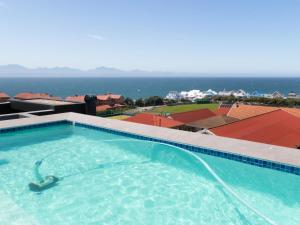 a swimming pool with the ocean in the background at 201 & 210 Mossel Cove in Mossel Bay