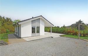 a small white house with a wooden porch at Holiday Home Sivsangervej Vestervig X in Vestervig