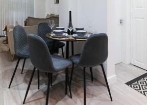 tavolo da pranzo con 4 sedie e bicchiere di vino di Downtown Cozy House in Manchester a Manchester