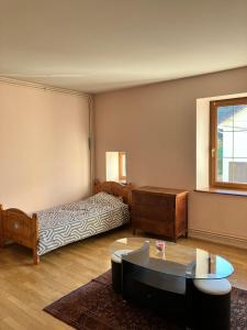 a bedroom with a bed and a coffee table at Gîte spacieux 8 personnes - Saint Joseph des Bruyères 1814 in Remiremont