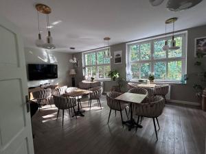 a dining room with tables and chairs and windows at Zamkowa 4 in Lubniewice