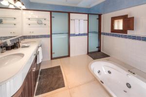 une salle de bain avec deux lavabos et une baignoire dans l'établissement Suite Embat im Es Llobets, à Llucmajor 15 autres photos