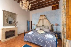 - une chambre avec un lit, une cheminée et un lustre dans l'établissement Suite Embat im Es Llobets, à Llucmajor