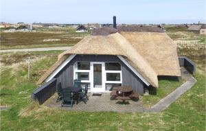 eine strohgedeckte Hütte mit Stühlen und einem Tisch in der Unterkunft Holiday Home Nordsø Ferievej Ii in Nørre Lyngvig