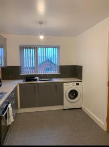 a kitchen with a washing machine and a sink at 4 Bedroom Contractors House in Sheffield +3 photos