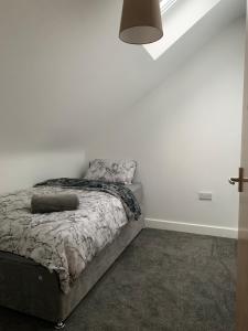 a bedroom with a bed and a white wall at 4 Bedroom Contractors House in Sheffield