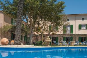 une piscine avec des arbres et un bâtiment dans l'établissement Suite Mestral im Es Llobets, à Llucmajor