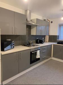 a kitchen with stainless steel appliances and gray cabinets at 4 Bedroom Contractors House in Sheffield